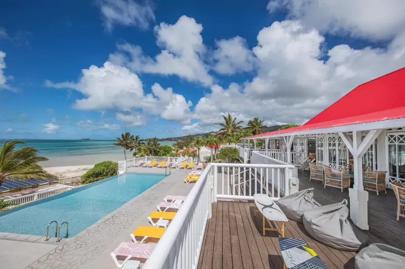 Terrasse avec piscine et vue sur la mer et la plage.