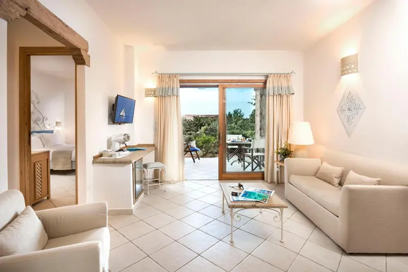 Espace de séjour lumineux avec canapés et accès à une terrasse.