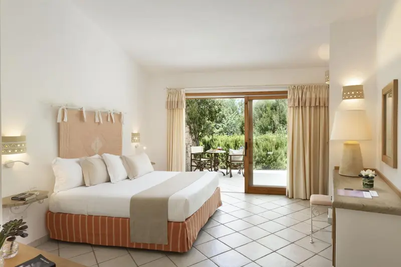 Une chambre lumineuse avec un grand lit et un accès à une terrasse.