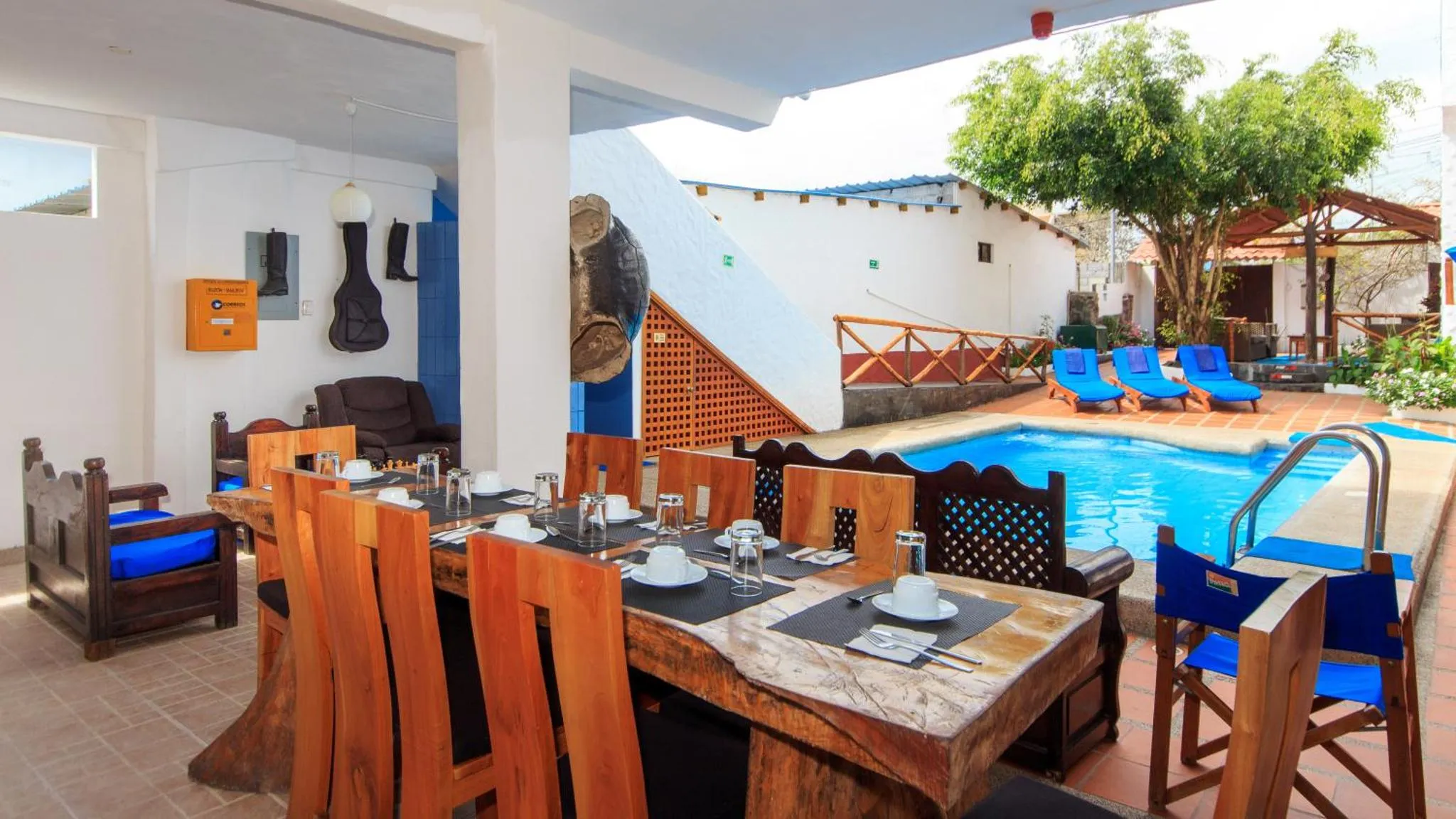Une table est dressée pour un repas en extérieur près d'une piscine.