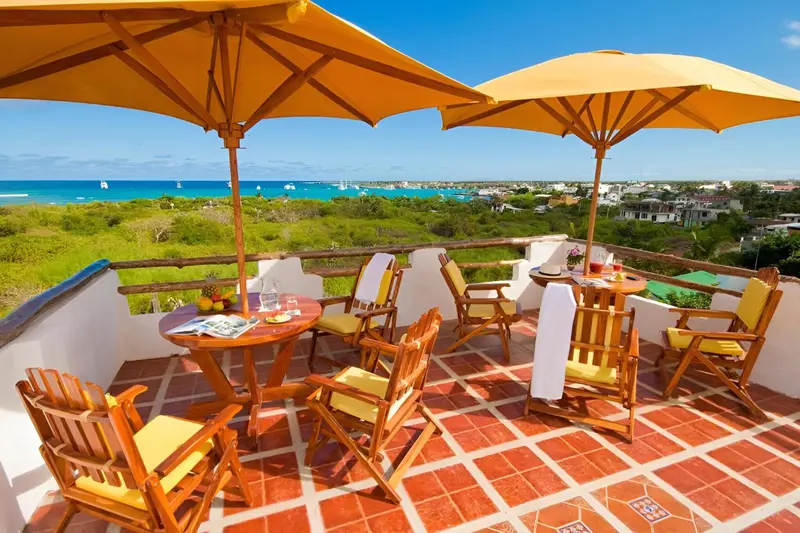 Terrasse avec mobilier de jardin et vue sur la mer.
