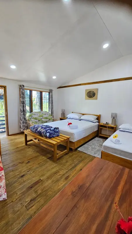 Une chambre lumineuse avec un lit double et un lit simple.
