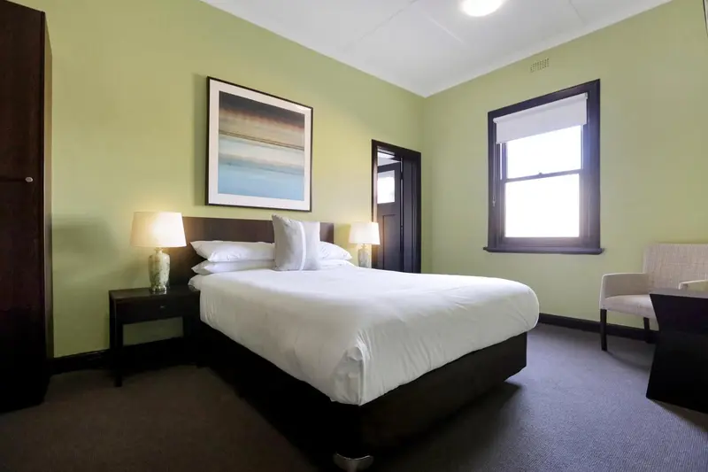 Une chambre lumineuse avec un grand lit et une fenêtre.