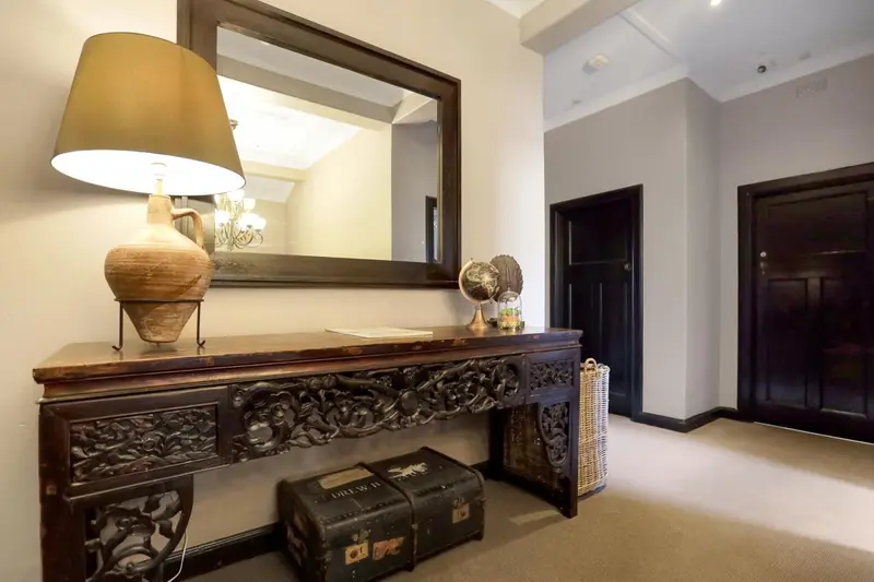 Console en bois sculpté avec une lampe et un miroir.