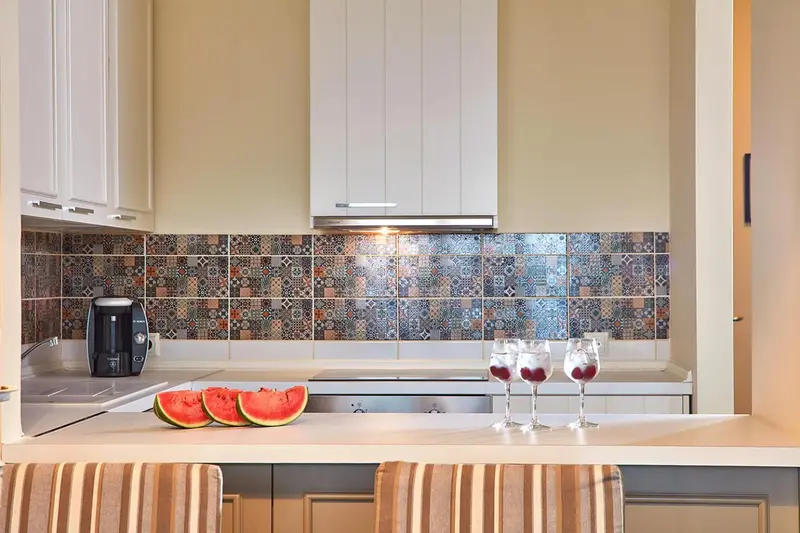 Une cuisine lumineuse avec un plan de travail décoré de fruits et de verres.