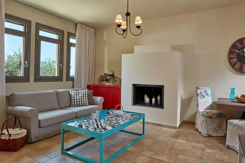 Un salon clair avec un canapé, une cheminée et une décoration murale.