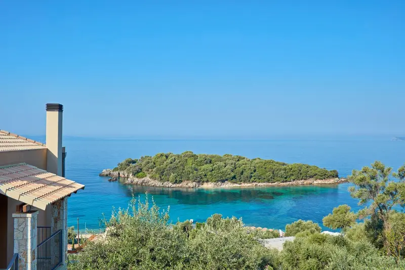 Vue sur une île verdoyante depuis une terrasse ensoleillée.