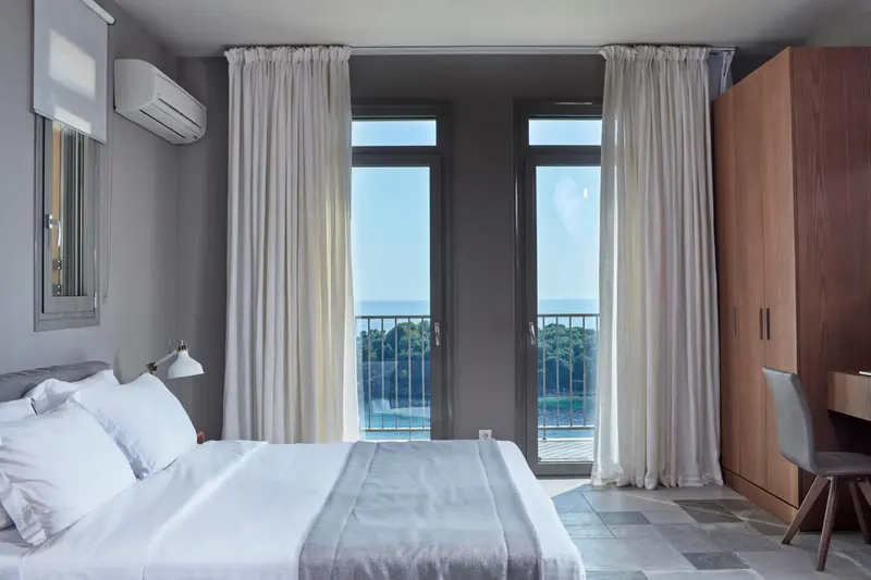 Une chambre lumineuse avec un grand lit et un accès à une terrasse.