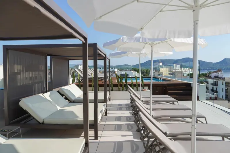 Terrasse aménagée avec transats blancs et vue sur la mer.