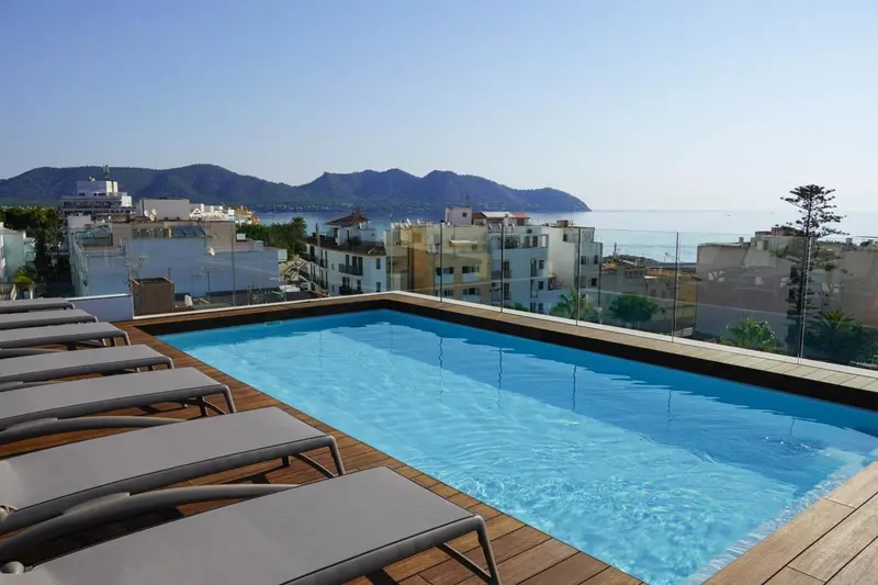 Une piscine sur le toit d'un bâtiment avec vue sur la mer et les montagnes.