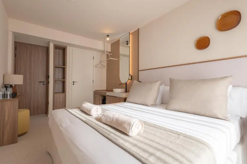 Une chambre lumineuse avec un grand lit et un espace rangement.