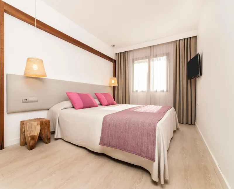 Une chambre lumineuse avec un grand lit et une décoration sobre.