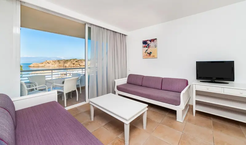 Un salon lumineux s'ouvre sur une terrasse avec vue sur la mer.