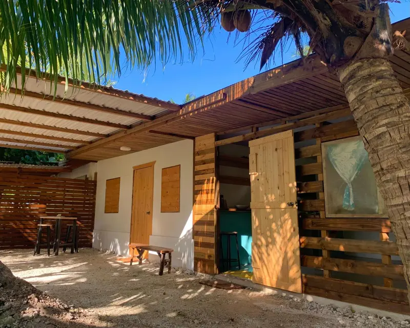Bâtiment ouvert sur une terrasse ensoleillée avec des tabourets hauts.
