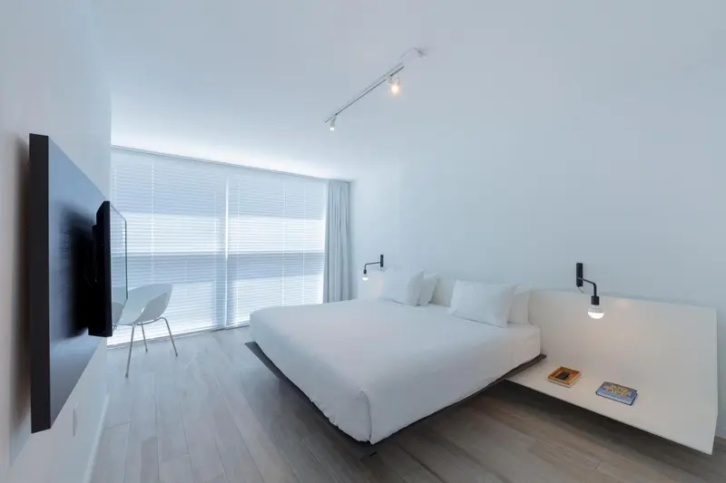 Une chambre lumineuse avec un grand lit et un bureau.