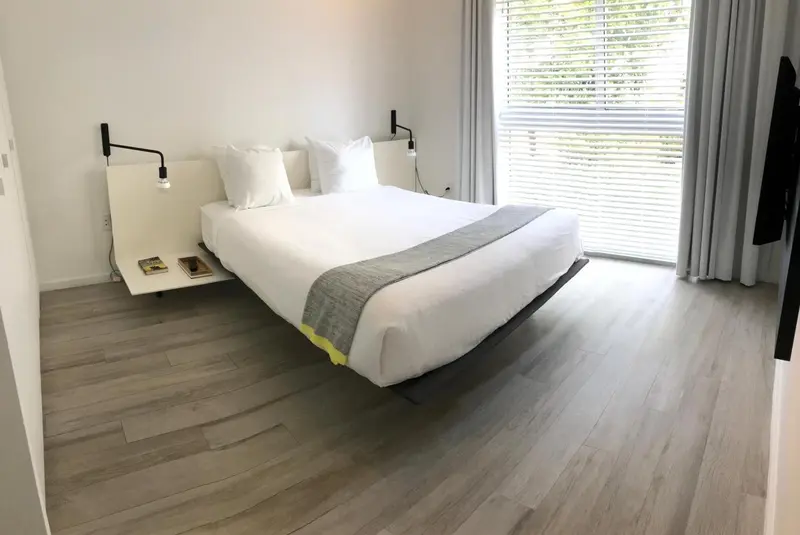 Une chambre lumineuse avec un grand lit et une décoration minimaliste.