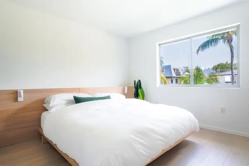 Une chambre lumineuse avec un grand lit recouvert de draps blancs.