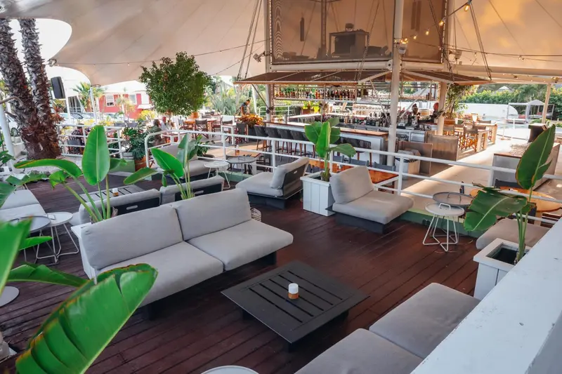 Espace de détente extérieur avec mobilier confortable et végétation luxuriante.
