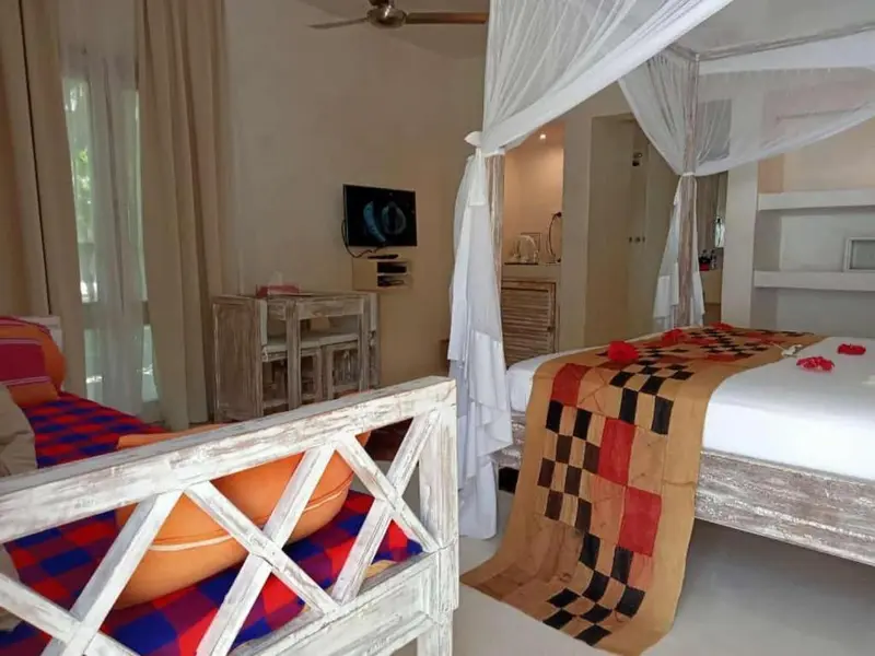 Une chambre lumineuse avec un lit à baldaquin et une décoration colorée.