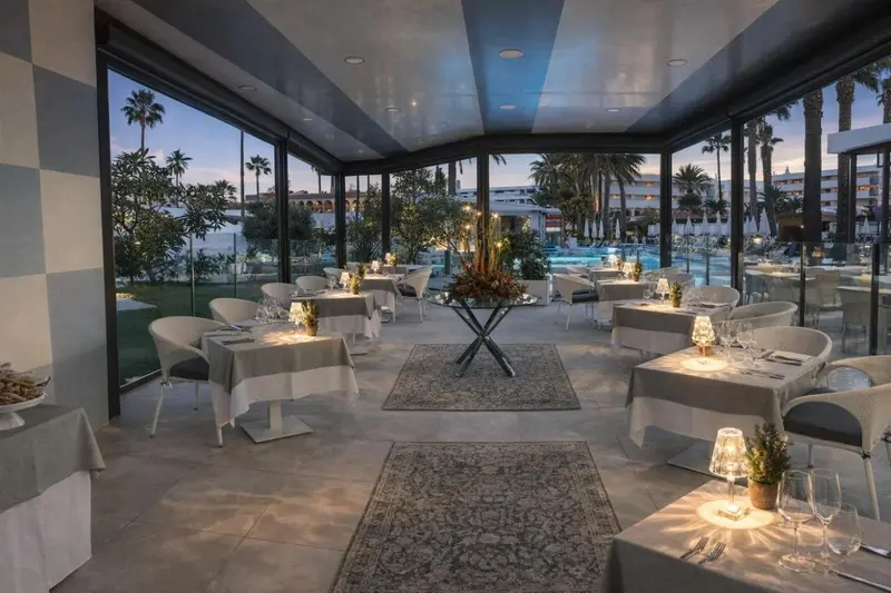 Une salle lumineuse avec des tables dressées pour un repas.