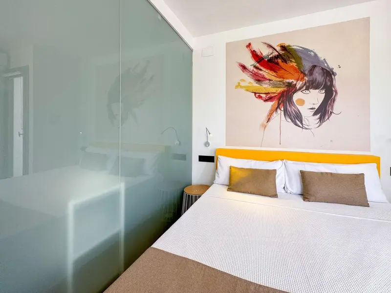 Une chambre lumineuse avec un grand lit et une décoration murale moderne.