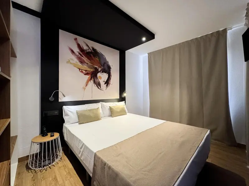 Une chambre lumineuse avec un grand lit et une décoration murale moderne.