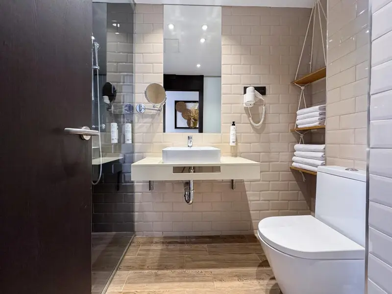 Une salle de bain moderne avec carrelage blanc et sanitaires.