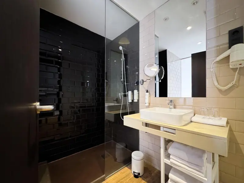 Une salle de bain moderne avec douche à l'italienne et vasque sur meuble.
