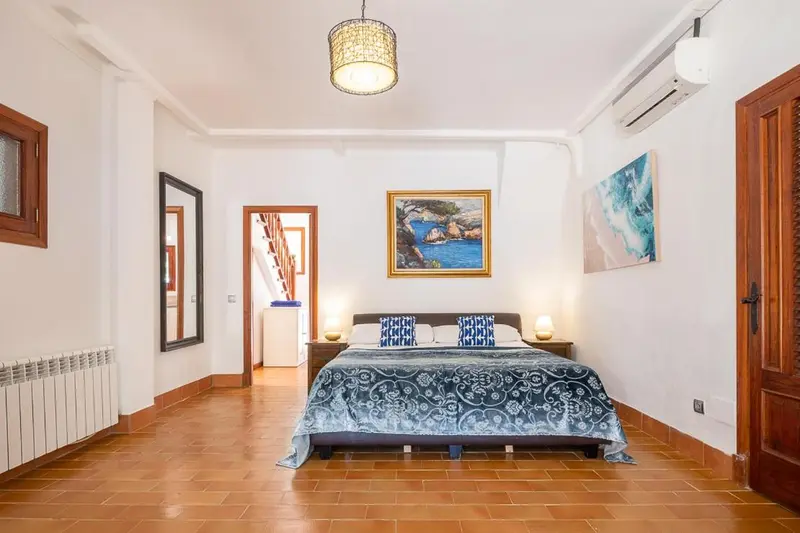Une chambre lumineuse avec un grand lit et une décoration murale.