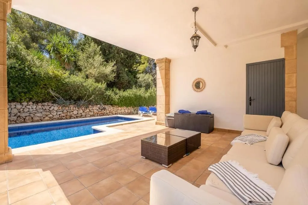 Espace de détente extérieur avec canapés et petite piscine.