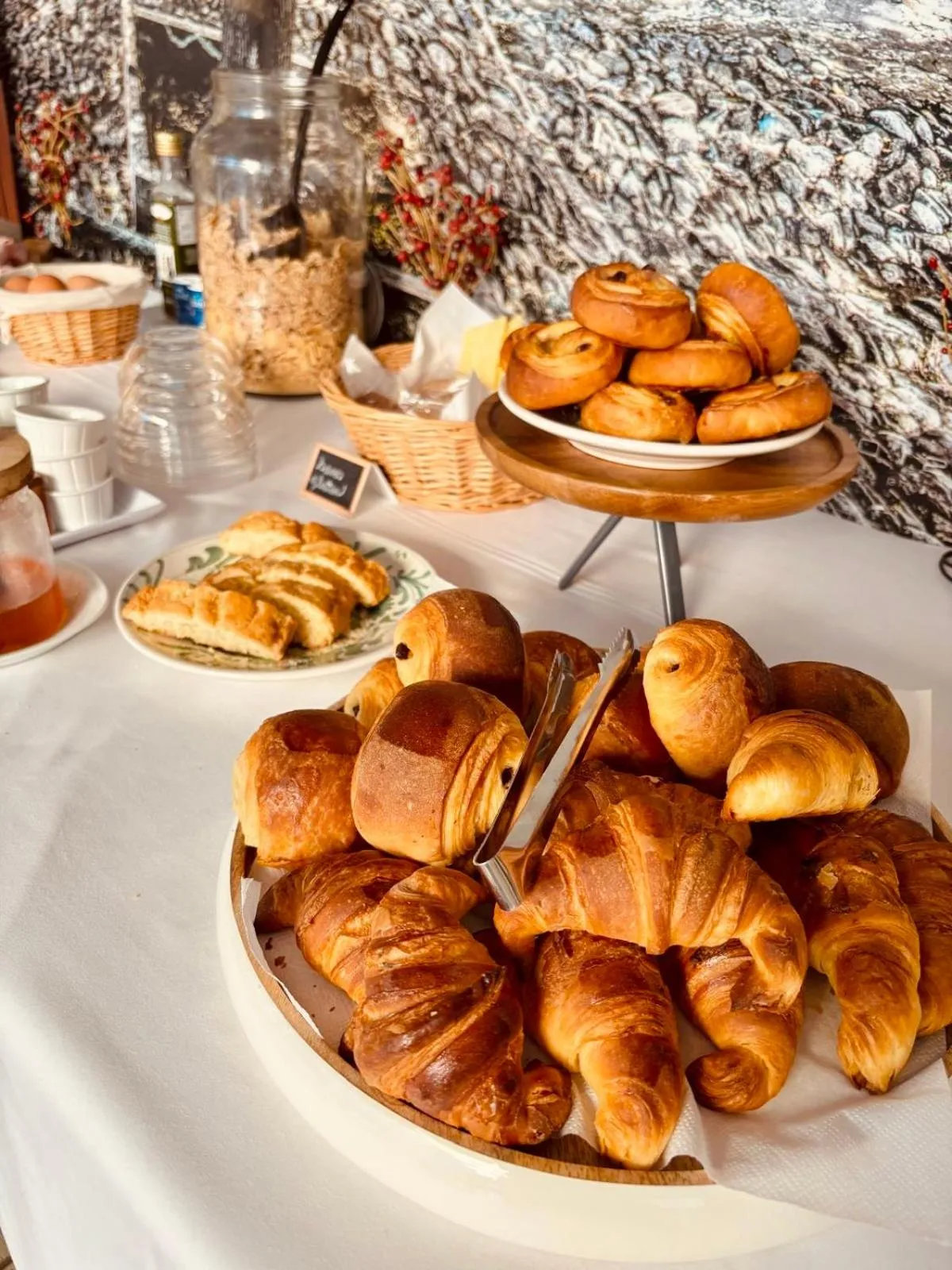 Une table garnie de viennoiseries et de céréales propose un buffet appétissant.
