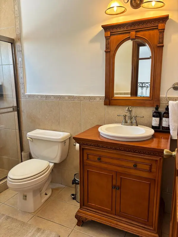 Une salle de bain avec lavabo, miroir et toilettes.