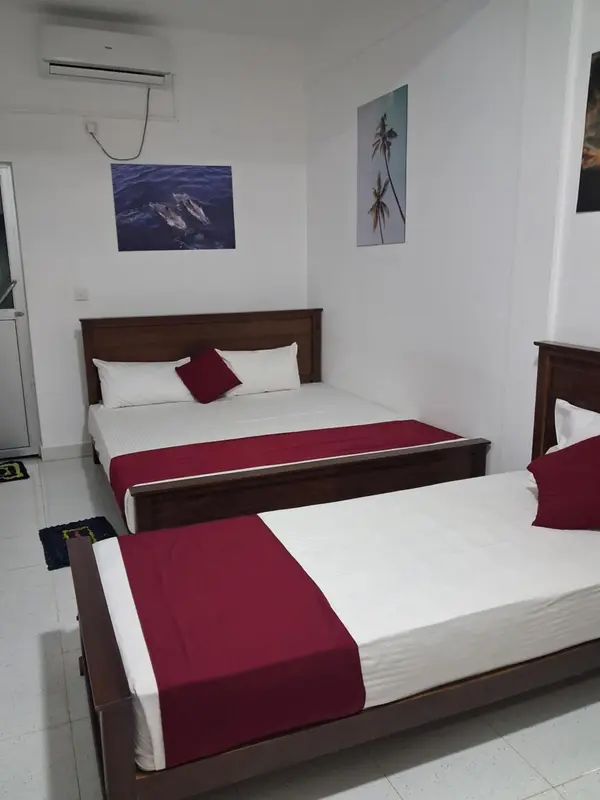 Une chambre avec deux lits simples et une décoration murale.