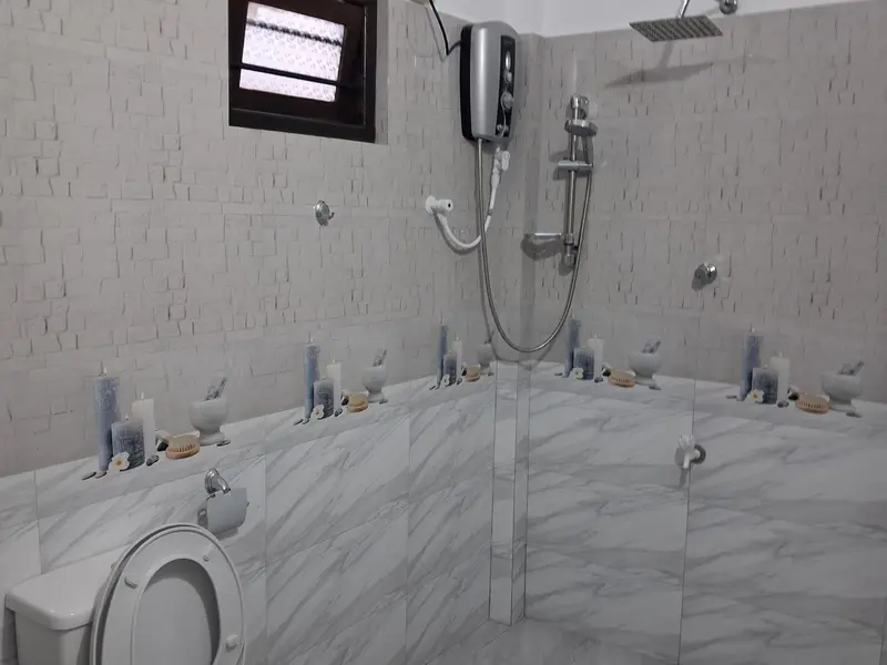 Une salle de bain moderne avec douche à l'italienne et carrelage blanc.