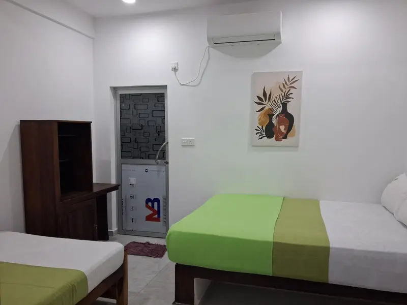 Une chambre lumineuse avec un lit et un meuble de rangement.