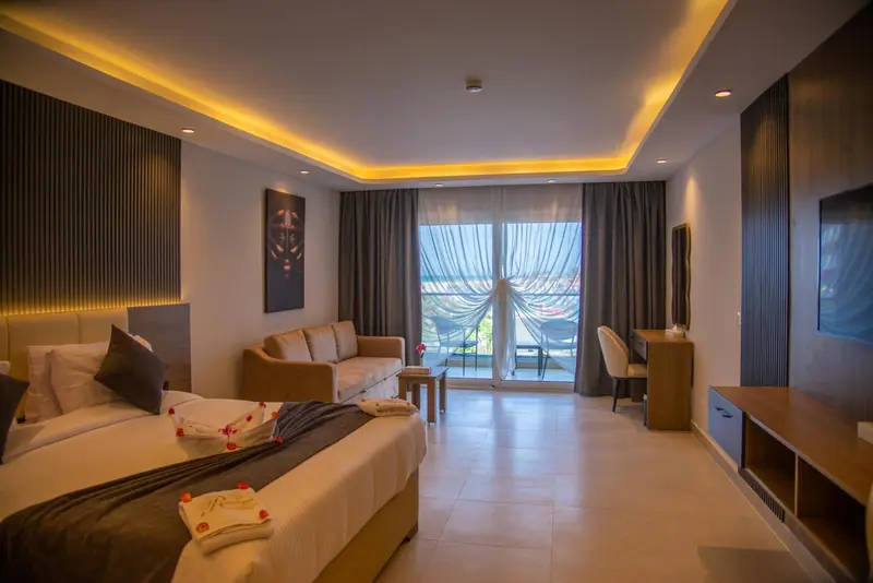 Une chambre lumineuse avec un lit et un espace salon donnant sur une vue extérieure.