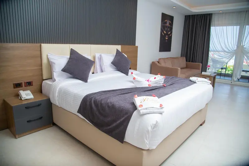 Une chambre lumineuse avec un grand lit et un canapé.