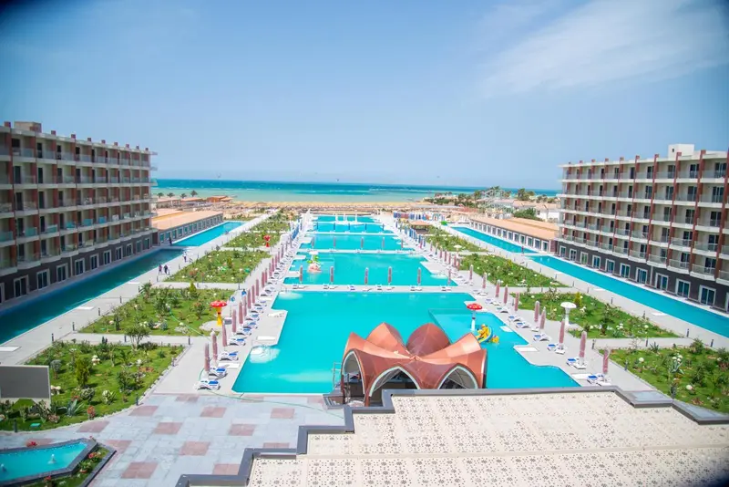 Vue aérienne d'un complexe hôtelier avec des piscines et des bâtiments modernes.