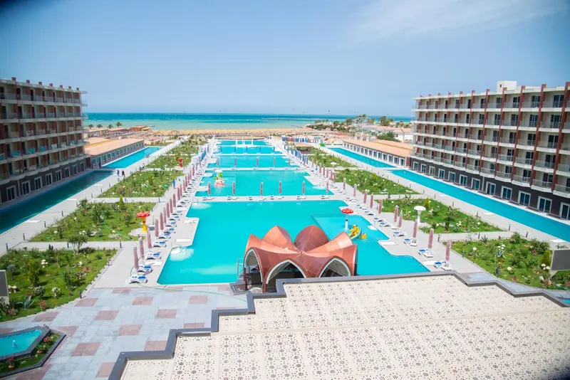 Vue aérienne d'un complexe hôtelier avec de grandes piscines et des bâtiments entourés de végétation.