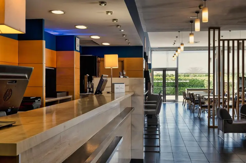 Un comptoir d'accueil moderne dans un hall d'hôtel lumineux.