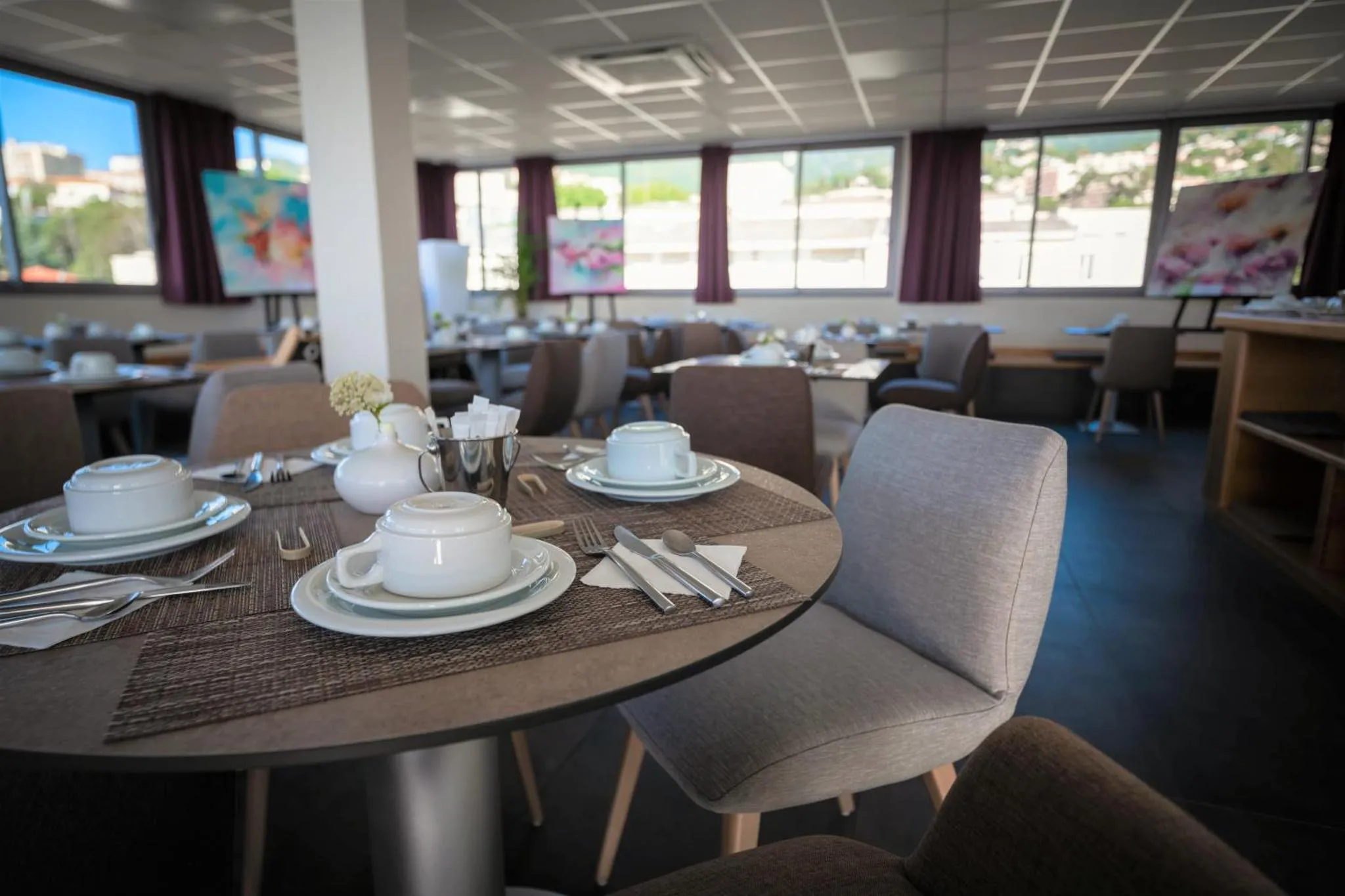 Une table est mise pour le petit-déjeuner dans une salle lumineuse.