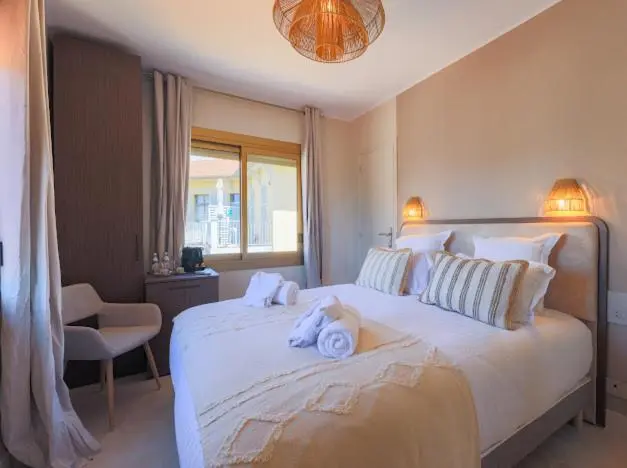 Une chambre lumineuse avec un grand lit et un coin salon.