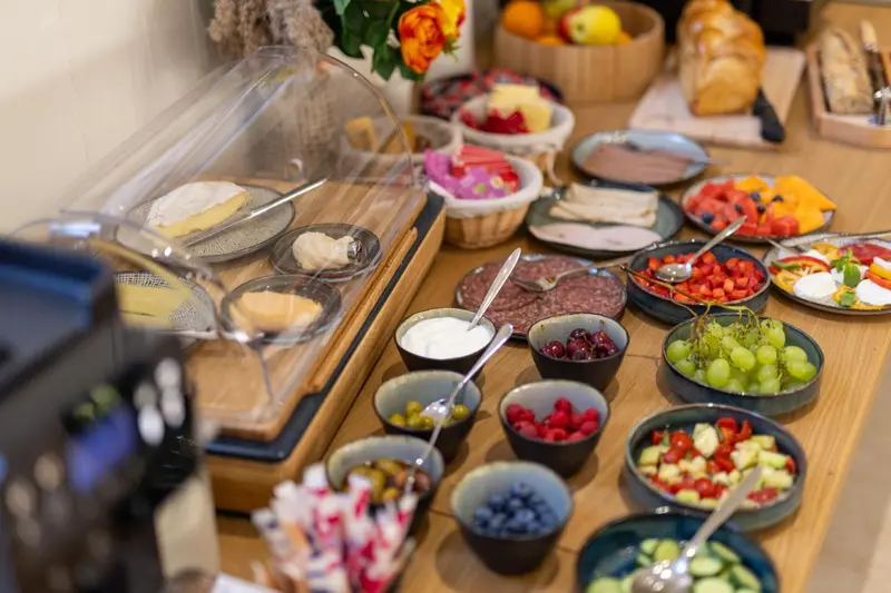 Un buffet propose une variété de viennoiseries, de fruits et de charcuteries.