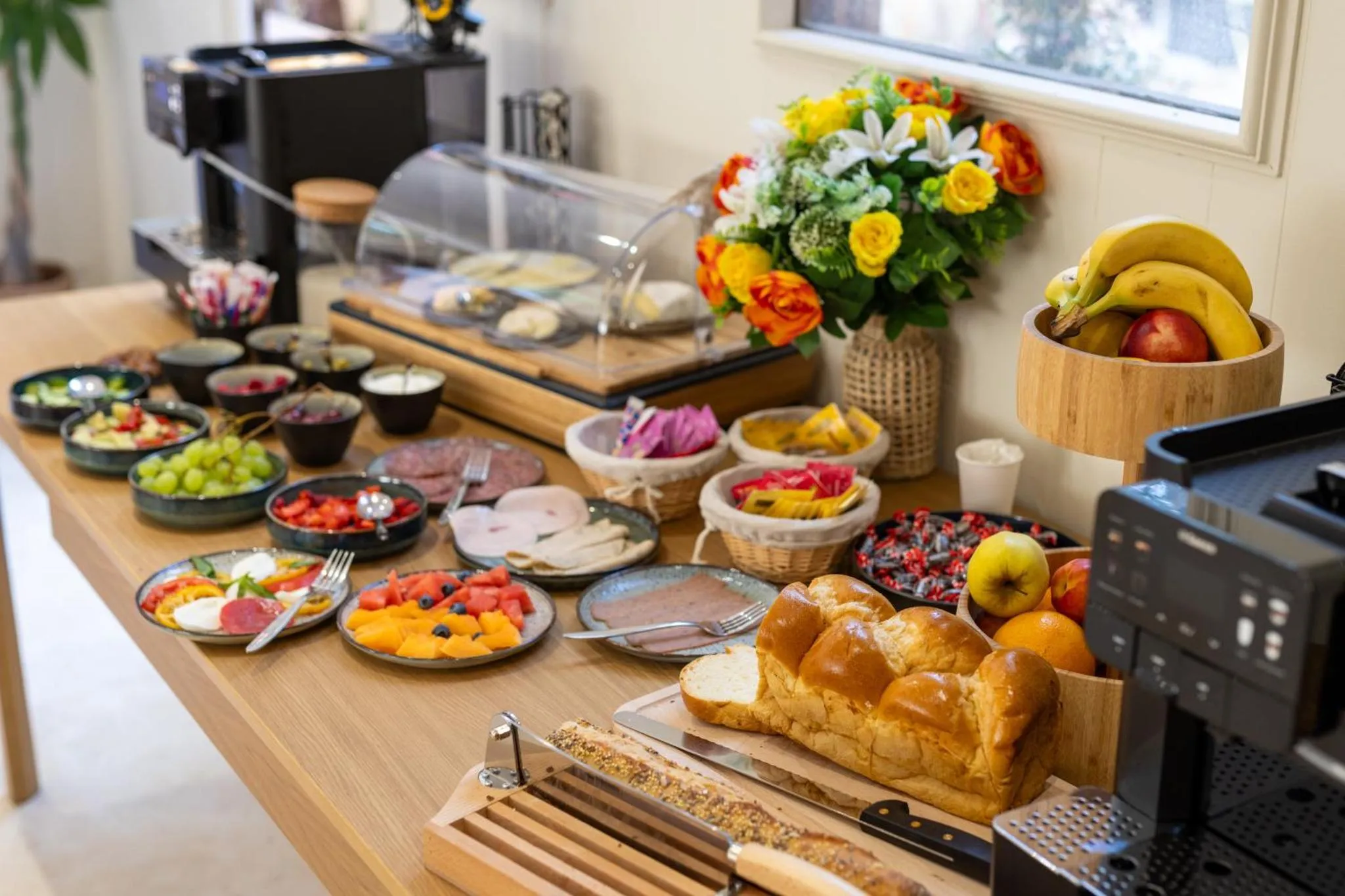 Un buffet propose une variété de viennoiseries, de fruits et de charcuteries.