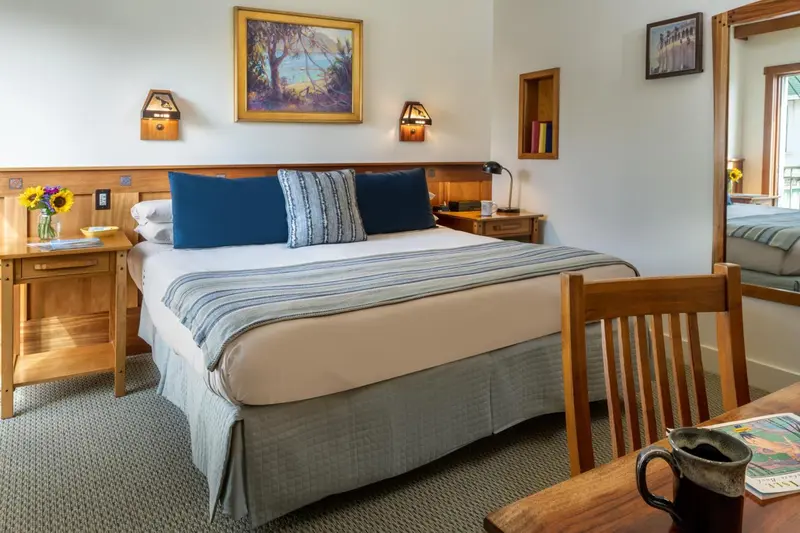 Une chambre lumineuse avec un grand lit recouvert d'une courtepointe.