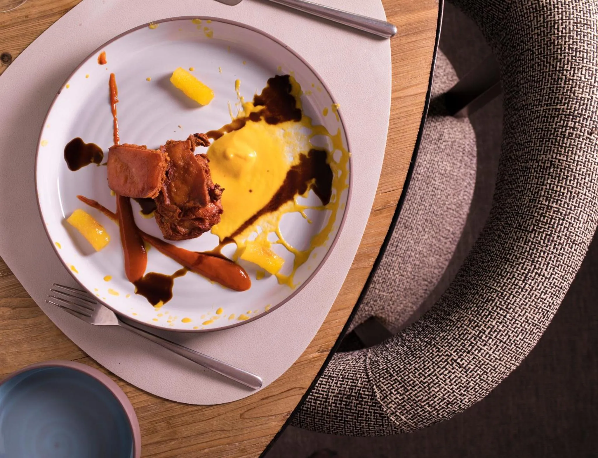Assiette présentée avec un plat composé de plusieurs éléments et une fourchette.