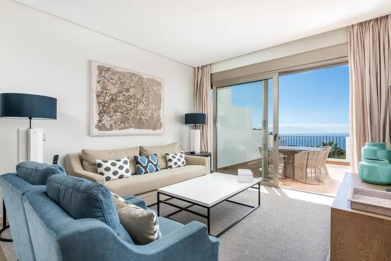 Un salon lumineux s'ouvre sur une terrasse avec vue sur la mer.