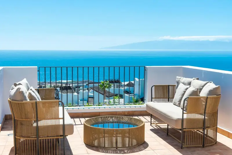 Terrasse aménagée avec mobilier d'extérieur et vue sur la mer.