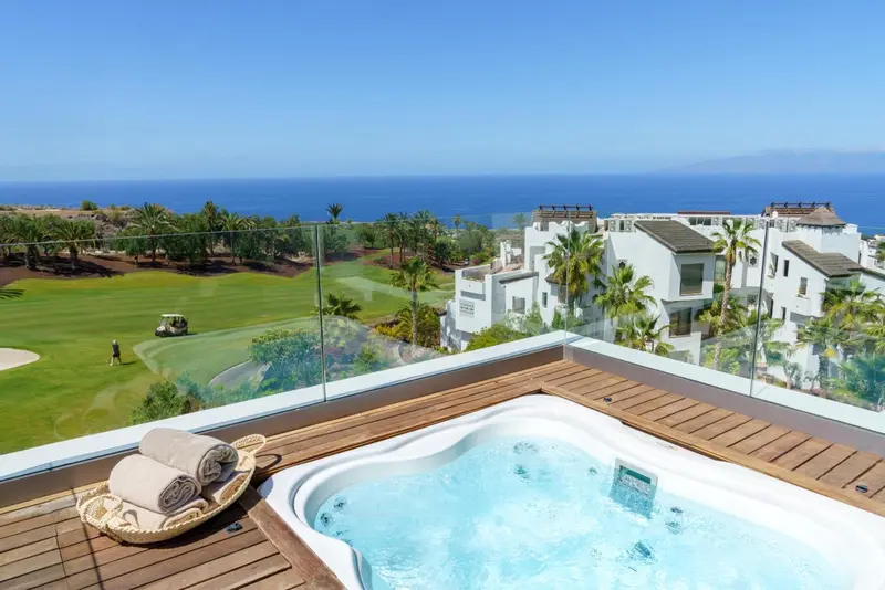Terrasse avec jacuzzi et vue sur la mer et un terrain de golf.