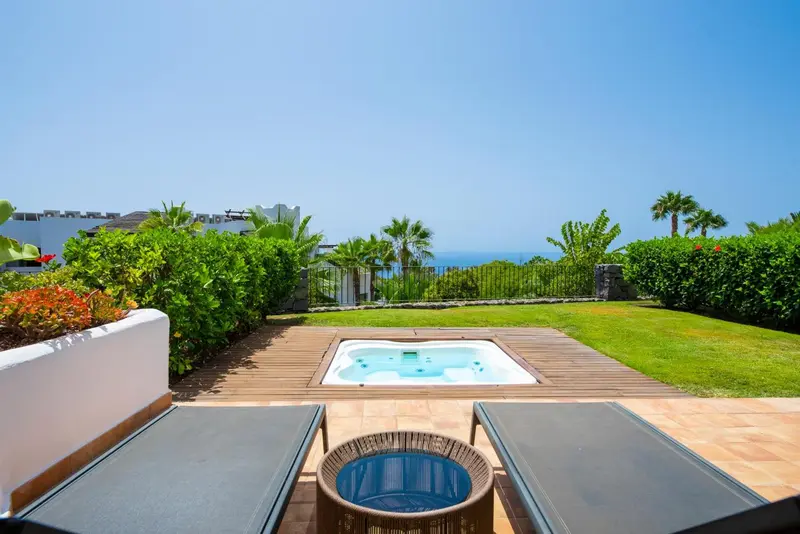 Terrasse avec jacuzzi et vue sur la mer.